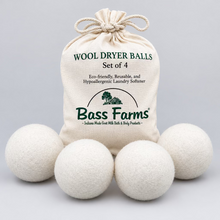Load image into Gallery viewer, Set of four Wool Dryer Balls with a branded bag on a green background
