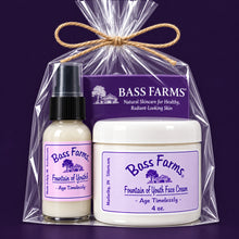 Load image into Gallery viewer, A packaged set of Bass Farms Fountain of Youth Face products including a gel serum and face cream, with labels and branding visible.