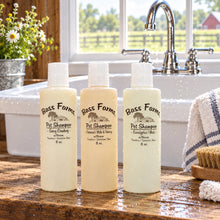 Load image into Gallery viewer, Three bottles of Bass Farms Pet Shampoo in different sizes placed on a wooden surface, with a white and light-colored liquid visible through the transparent bottles.