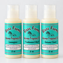 Load image into Gallery viewer, Three bottles of Boss Farms Fragrance Oil arranged vertically on a speckled granite countertop. The bottles contain a pale yellow liquid and feature light green labels with brown text and graphics.