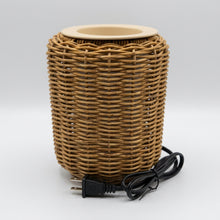 Load image into Gallery viewer, A cylindrical woven rattan or wicker lamp base in a natural tan-brown color, with a light beige ceramic pot on top and a black power cord. Text at the bottom reads '5 1/2" Wide x 7" Tall'.