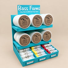 Load image into Gallery viewer, Bass Farms product display with jars and boxes on a beige background