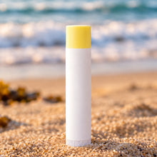 Load image into Gallery viewer, A stick of lip balm labeled 'Zinc Oxide' placed on a wooden surface.