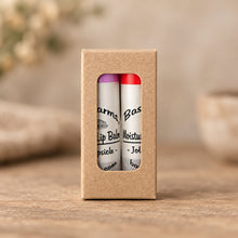 Load image into Gallery viewer, Two lip balms packaged in a simple cardboard sleeve with a clear window displaying the products.