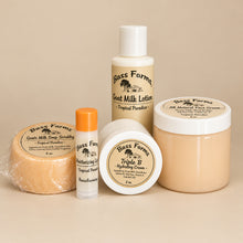 Load image into Gallery viewer, A set of Bass Farms skin care products including goat milk soap, exfoliating sugar scrub, moisturizing goat milk lotion, triple B hydrating cream, and lip balm, displayed on a wooden surface.